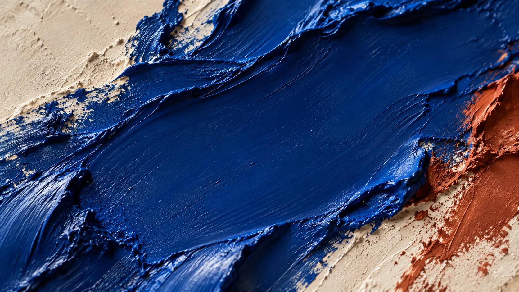 Makroaufnahme von plastischen ultramarinblauen Farbstrukturen auf mineralischem Untergrund.